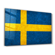 Sweden Flag Splash glass wall art by Artdesigna, featuring vibrant red and blue colors in a splash design on clear glass.